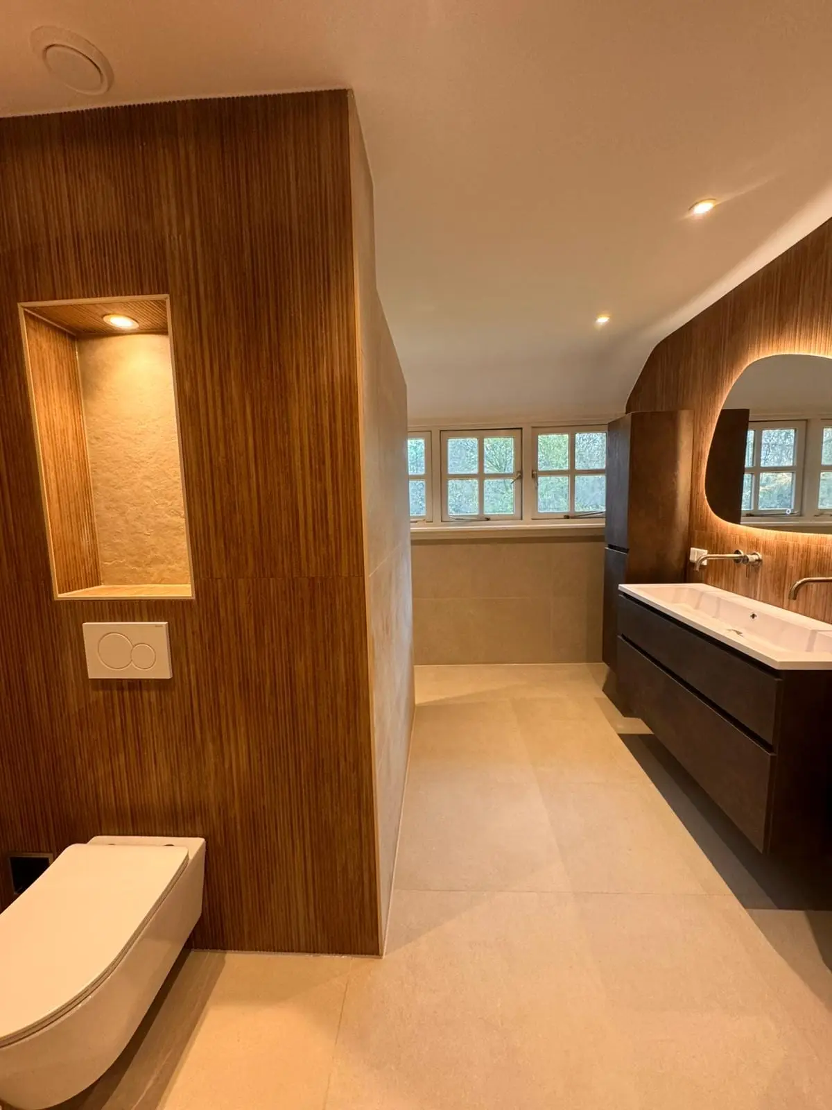 Badkamer met houten afscheiding en hangend toilet