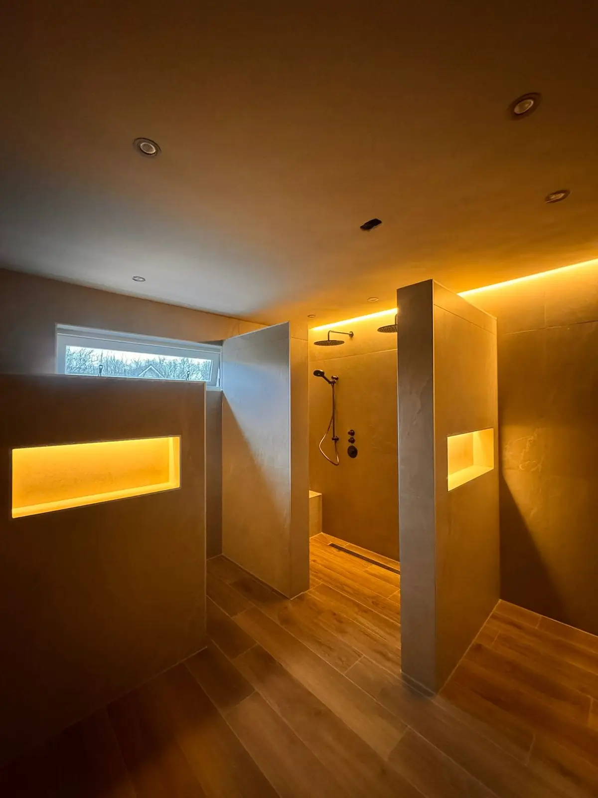 Badkamer met verlichte wandnissen en warme indirecte verlichting