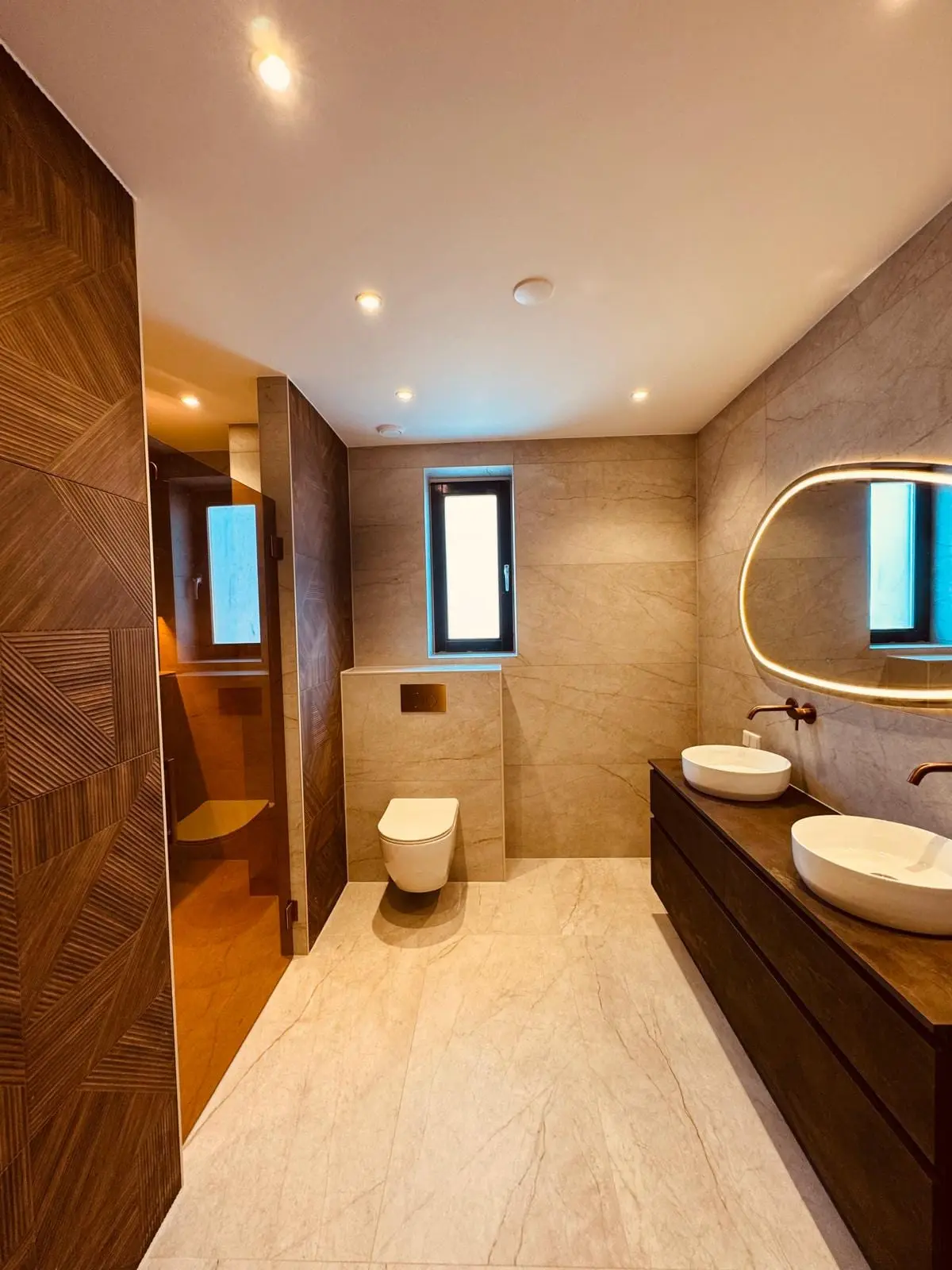 Badkamer met hangend toilet, opzetkom en warme wandtegels