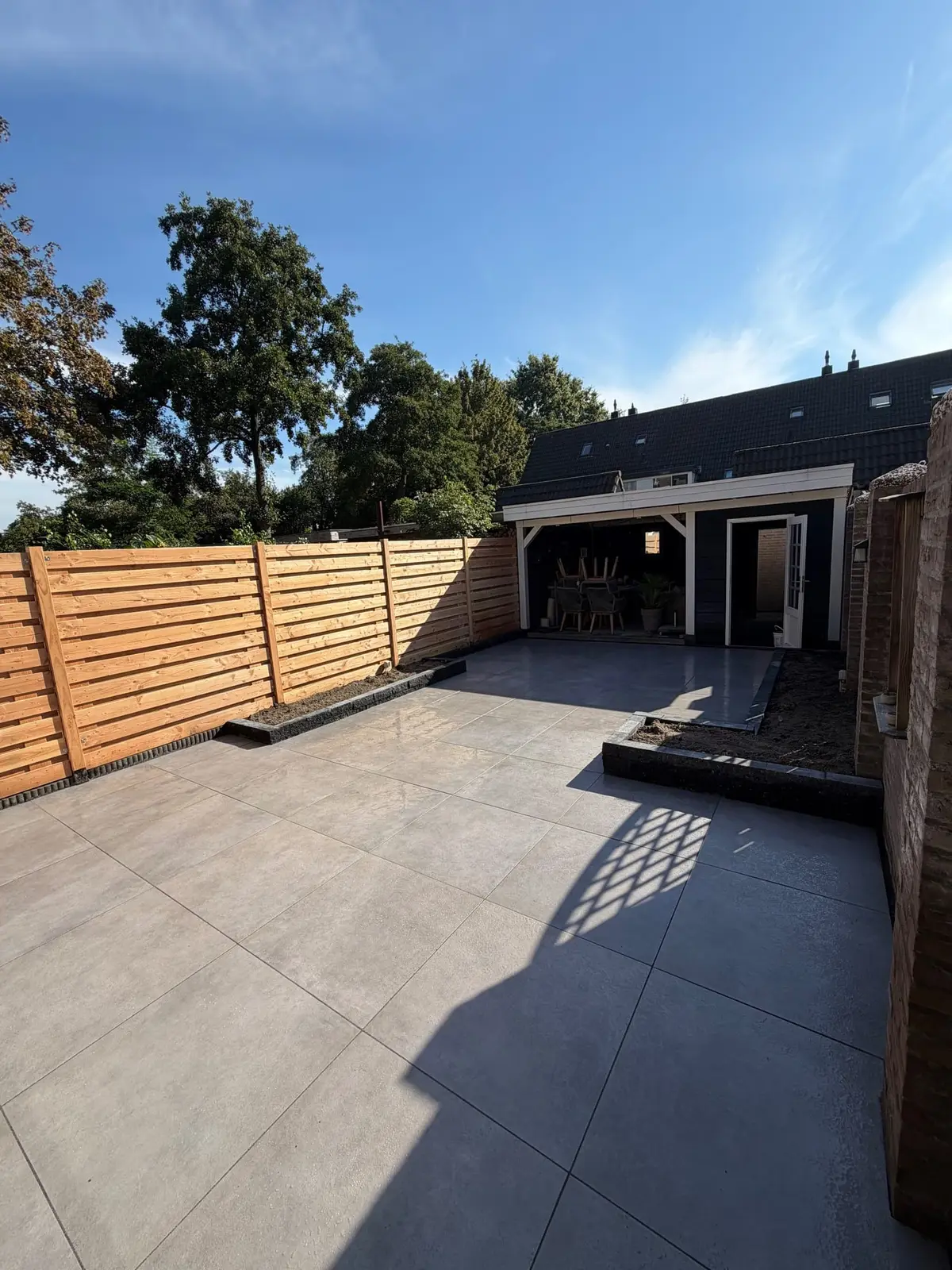 Bestrating tussen de woning, schutting en achterste zitplek