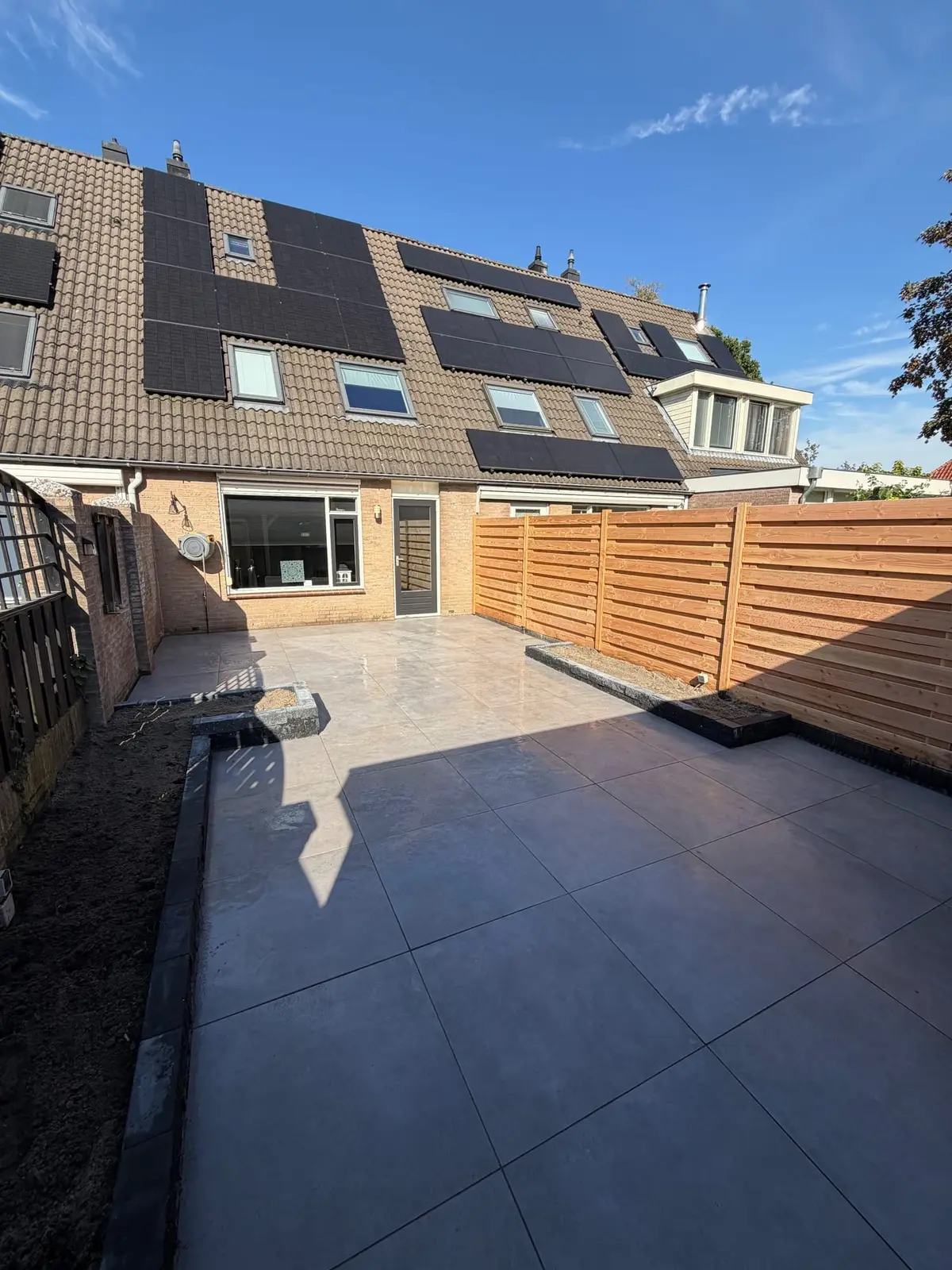 Zicht vanaf het terras naar de achtergevel van de woning