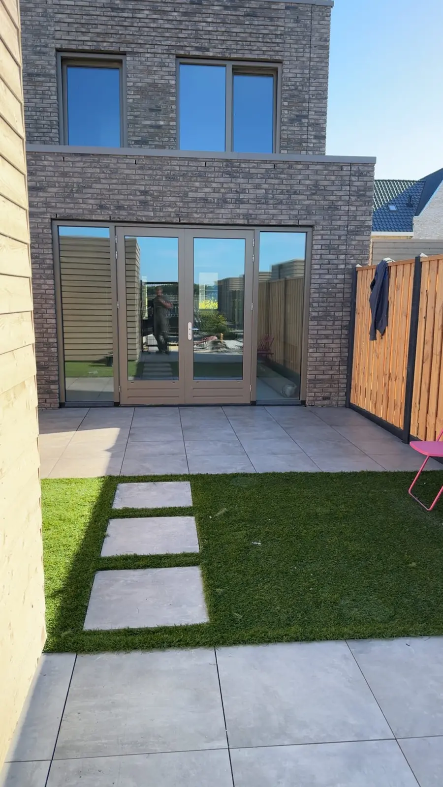Staptegels door het kunstgras naar het terras bij een nieuwbouwwoning