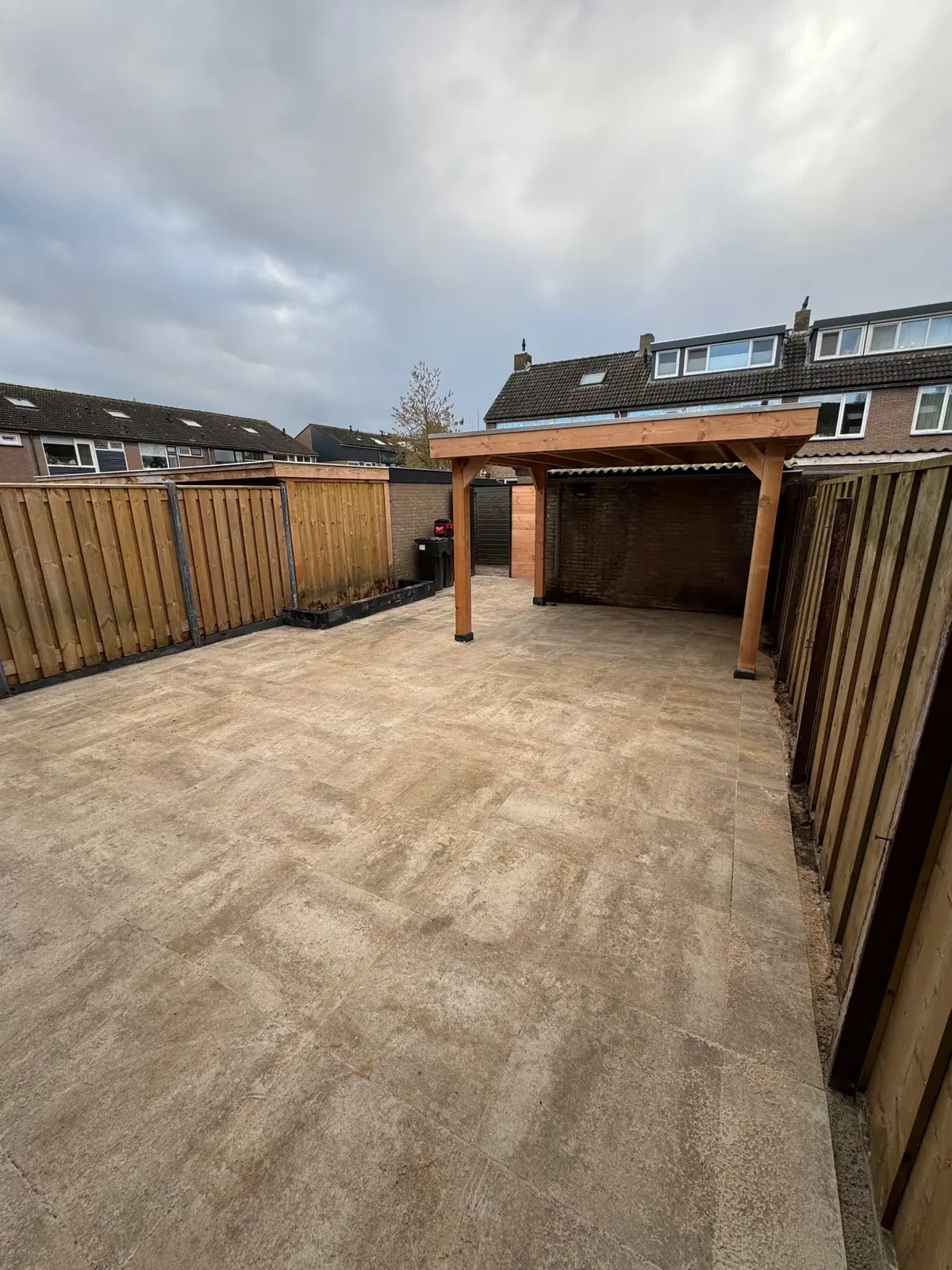 Volledige tuin met bestrating en overkapping aan de achterzijde