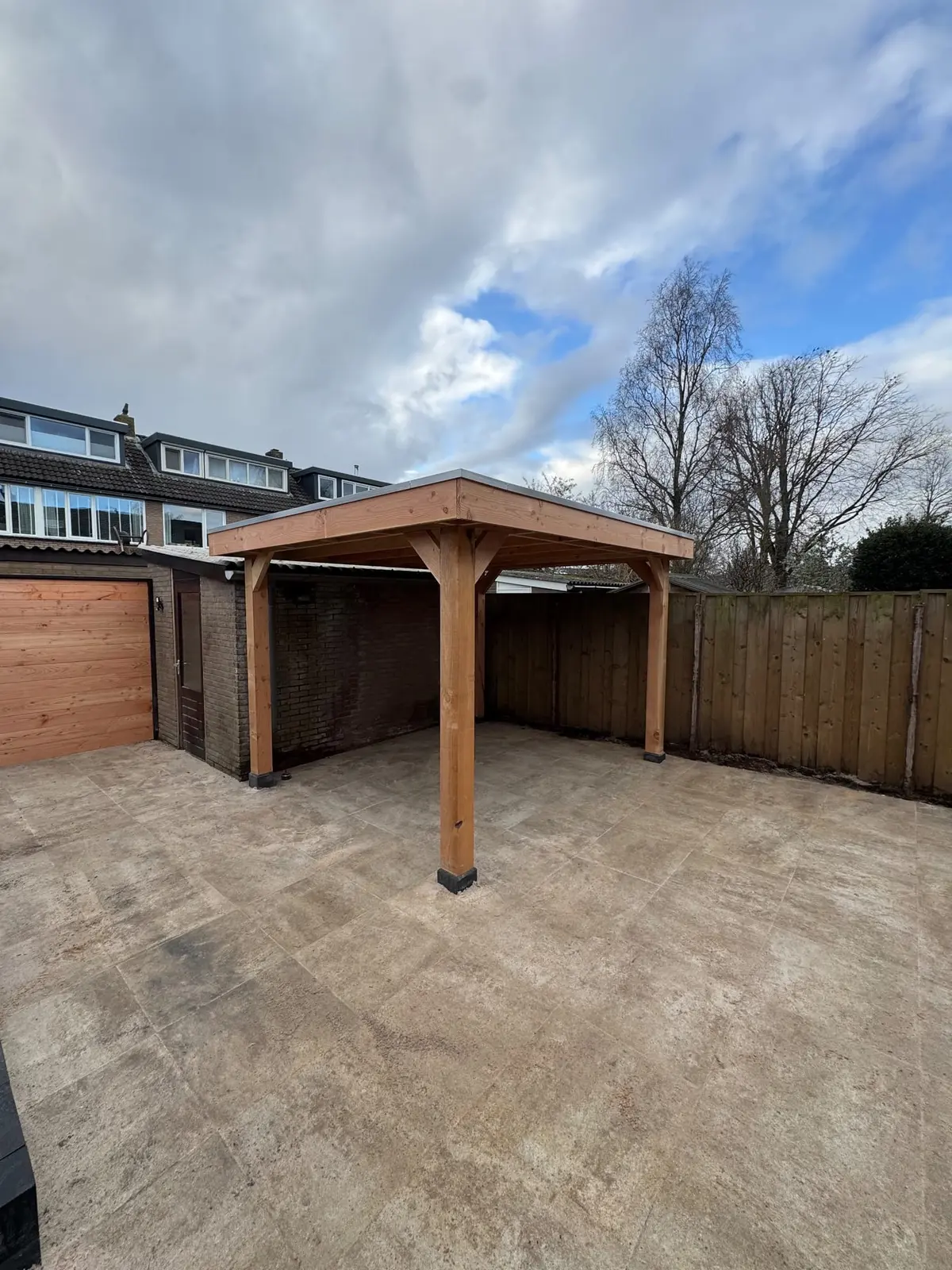 Houten overkapping met open staanders boven het terras