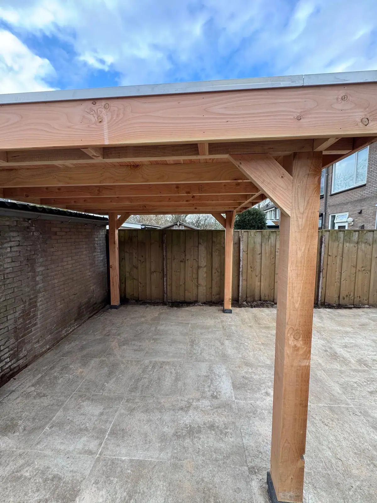 Houten dakconstructie en staander boven de nieuwe bestrating