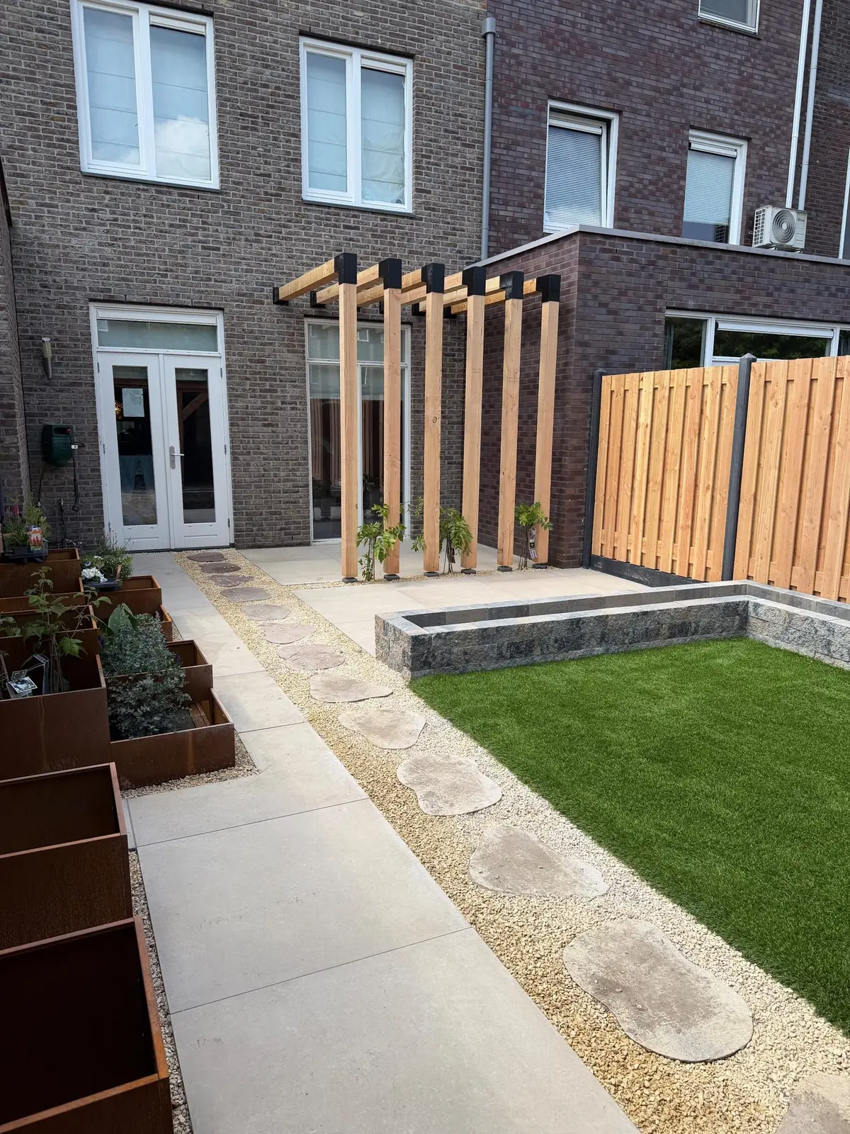 Pergola en bestrating bij de achtergevel in Vathorst