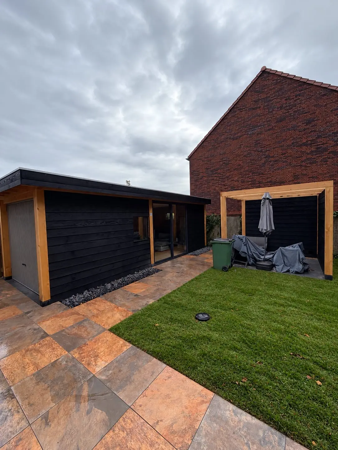 Vernieuwde tuin in Ede met bestrating, groen en overkapping