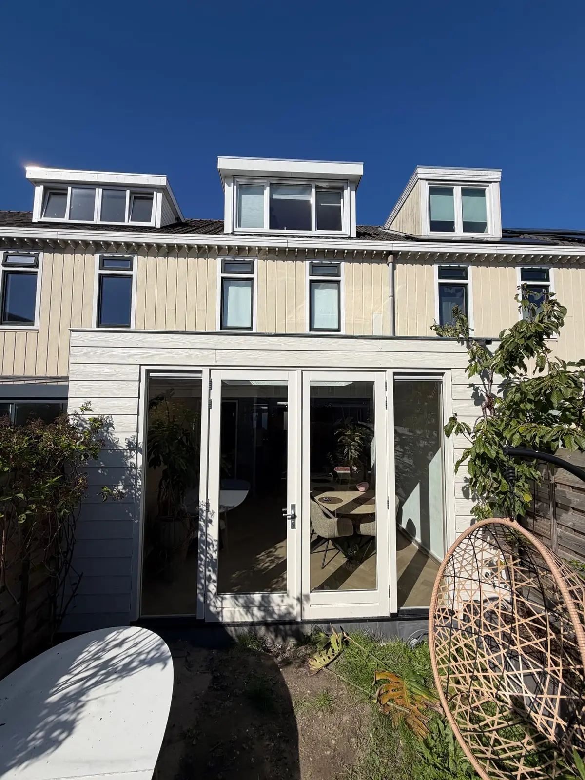 Nieuwe achtergevel van de uitbouw met glazen deuren
