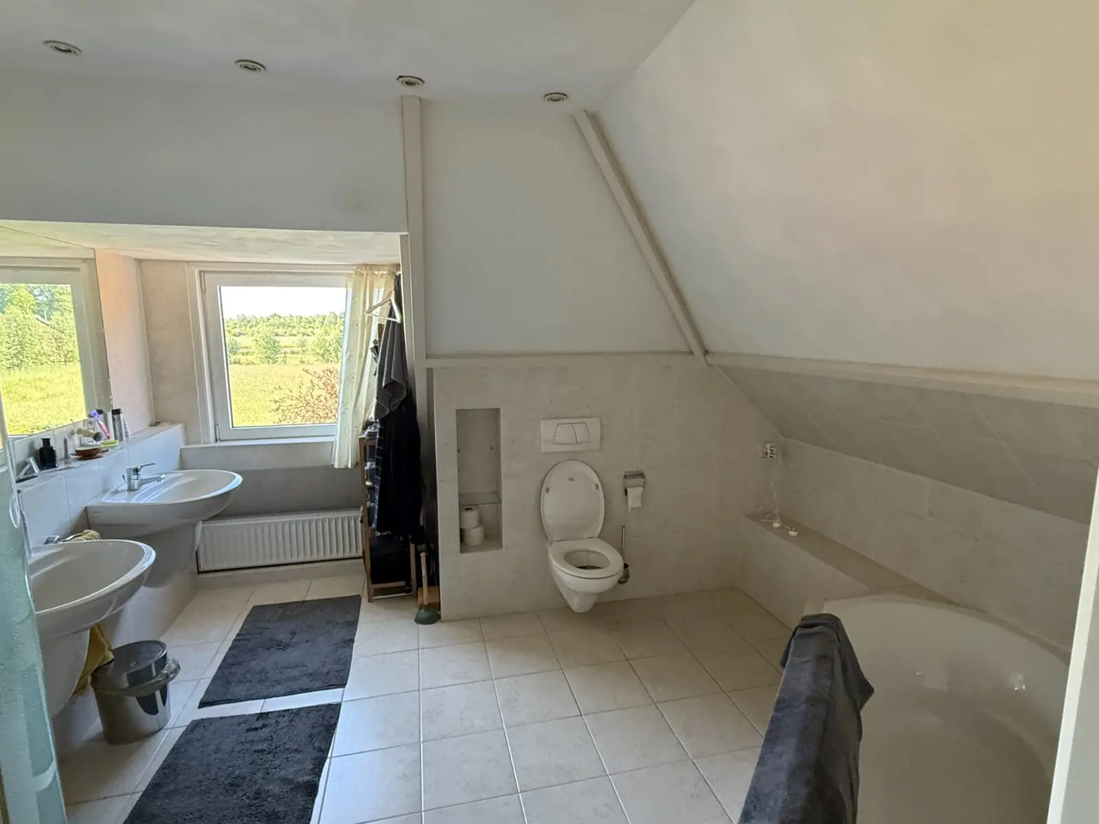 Bestaande badkamer met ligbad, toilet en dubbele wastafel